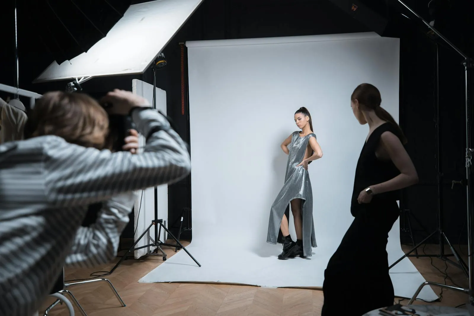 Behind the scenes: a stylist adjusting a silk frame while the photographer reviews tethered captures on a calibrated Eizo monitor.