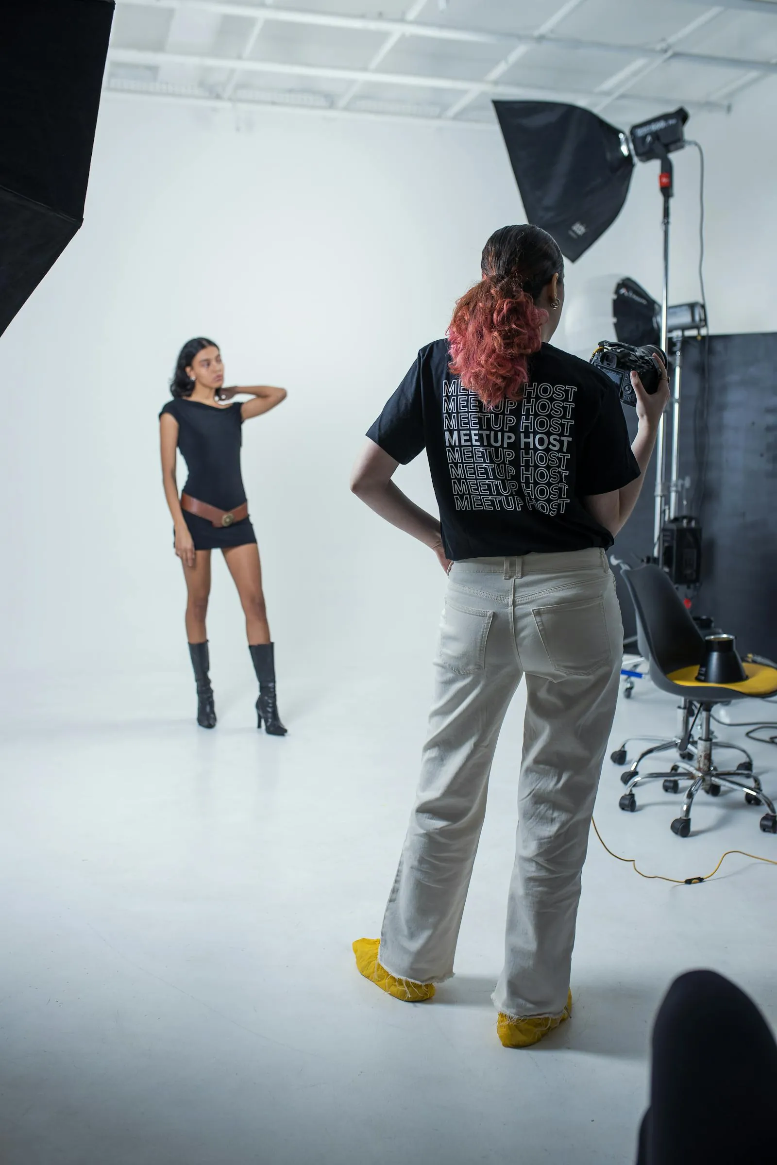 The Brooklyn studio with a 4×6 silk on a C-stand, a model in profile, and a producer reviewing selects on an iPad.